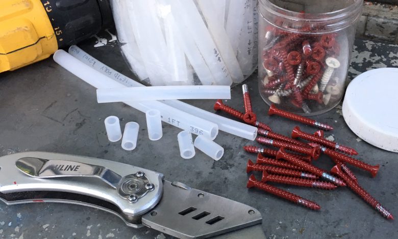 A box cutter with a sharp blade makes quick work cutting strips of tubing kept in a jar into spacers of various lengths.