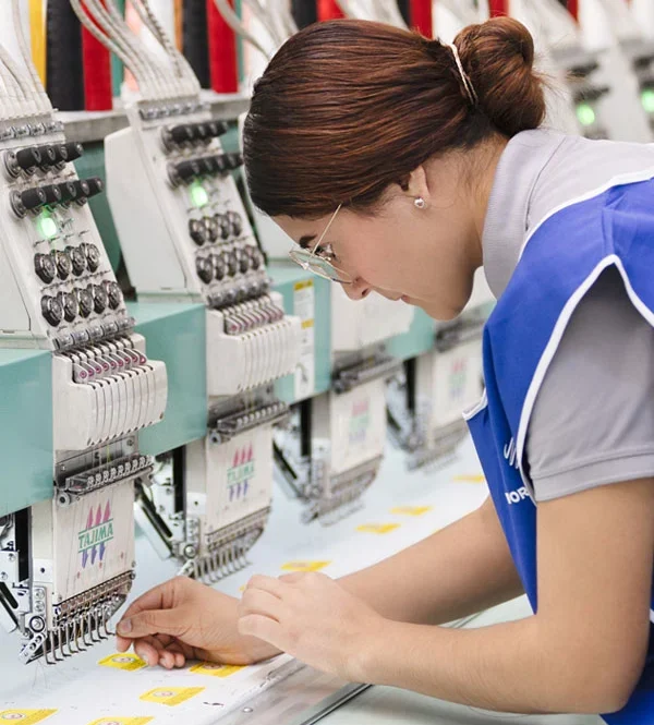 worker at embroidery machines - world emblem