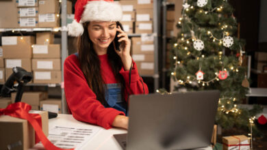 holiday Warehouse manager in Santa hat pick up phone purchase order stock detail customer online data delivery at storehouse. Startup small business