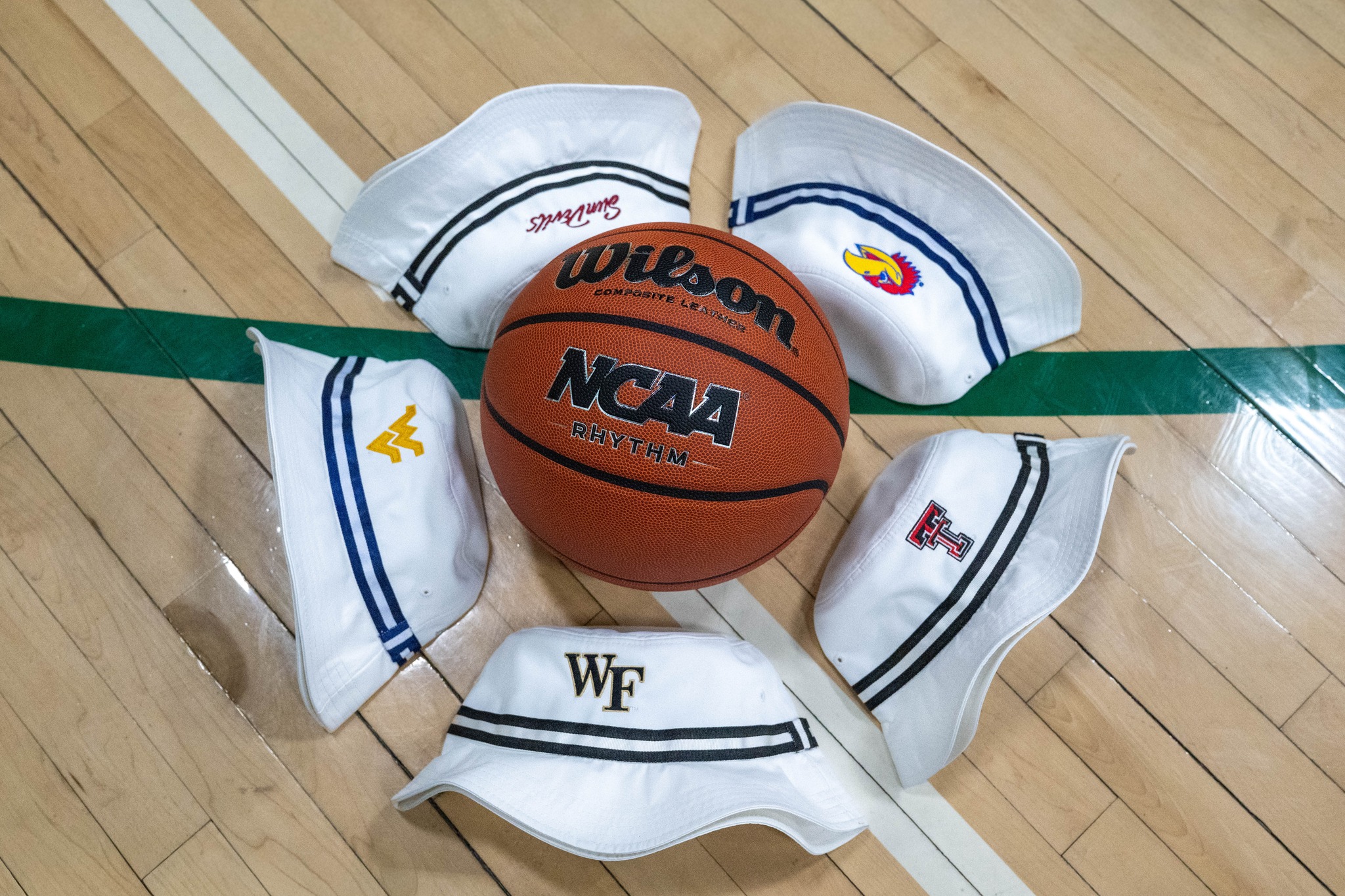 hats with college logos surrounding basketball - Image courtesy of Imperial