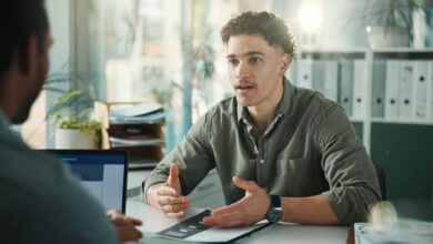 Resume, job interview and business men in office for meeting, recruitment or finance vacancy. Discussion, paperwork and hr manager with candidate for hiring process with documents in workplace; employee retention