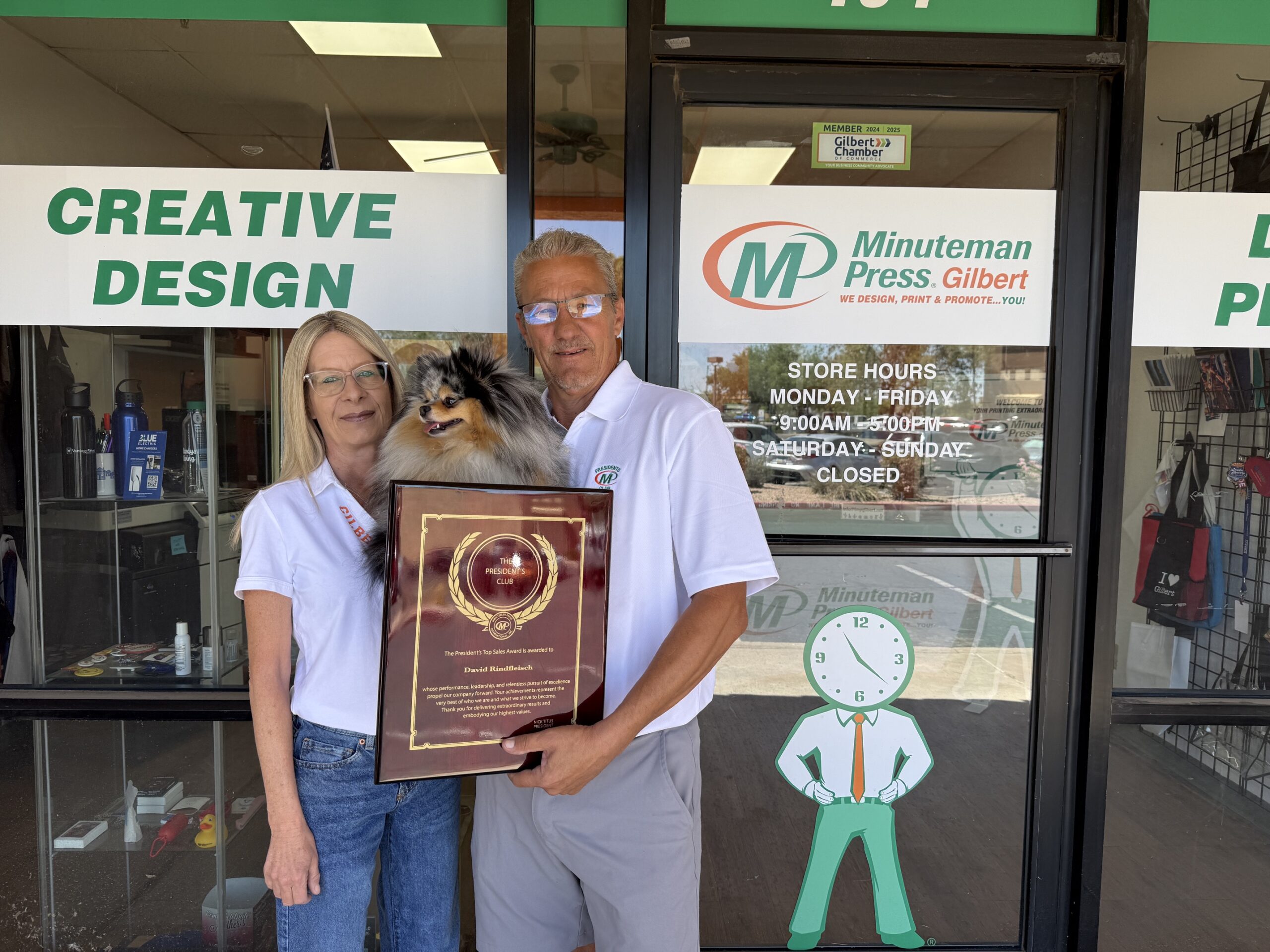 Minuteman Press Franchise Owners Angel & Dave Rindfleisch (with Balee) celebrate their President’s Club Award outside their center in Gilbert, AZ.