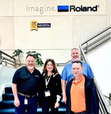 Pictured at Roland DGA headquarters (from left): Dan Johansen, Vice President of Business Development, Roland DGA; Susan Cox, Founder & CEO, LogoJET; Sid Lambert, Director of Sales, Roland DGA (rear); and Dan Burmeister, CEO/President, Roland DGA (front right). Photo courtesy of LogoJET.